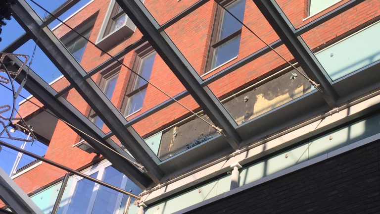 Glasplaten vallen van woningmuur in De Mare in Alkmaar